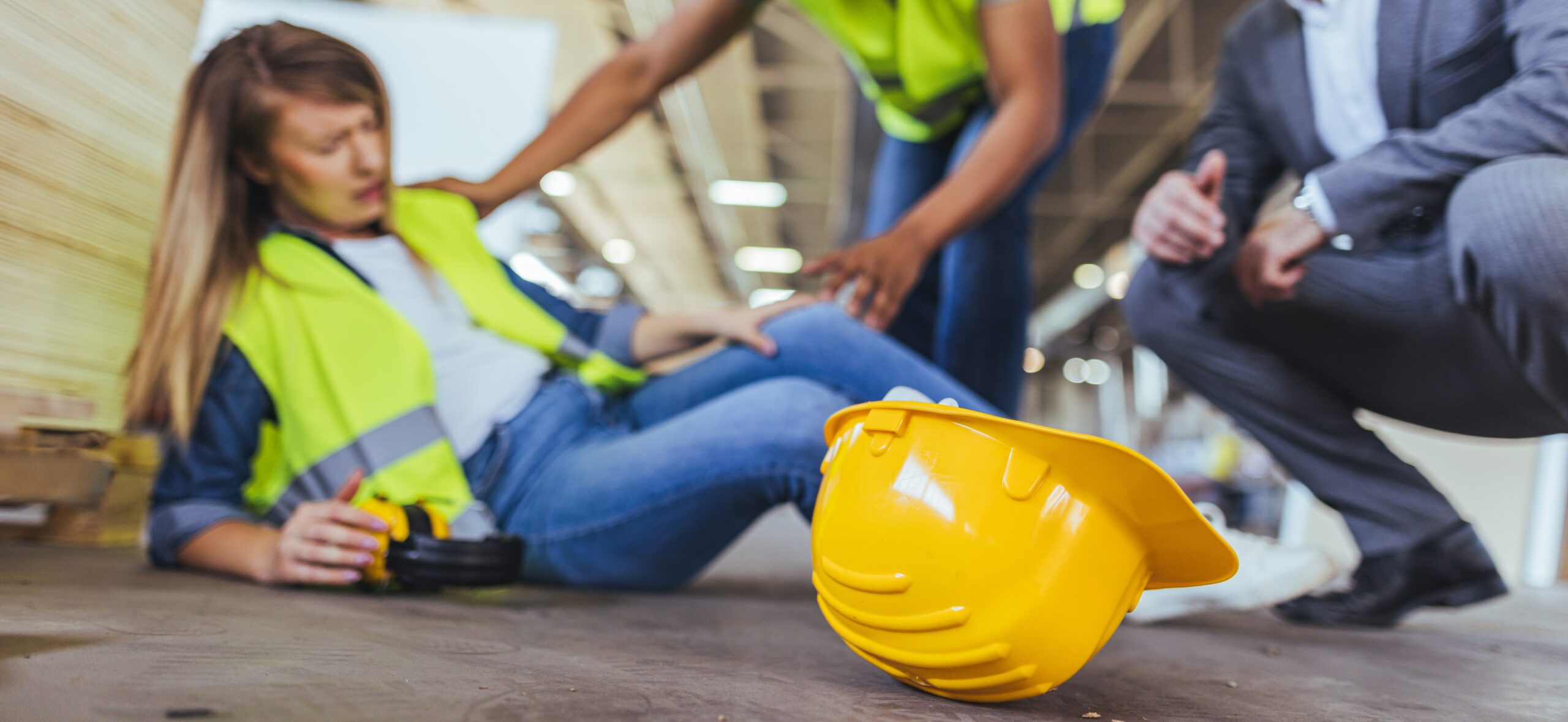 Construction worker injured in jobsite fall. Injured construction worker on the ground after a jobsite fall, hard hat in focus